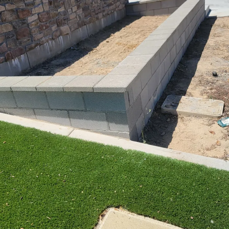 Stone faced planter wall meeting a level lawn in Sacramento