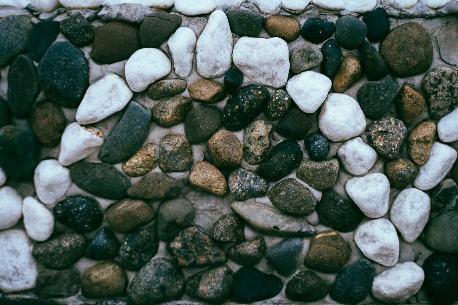 A mason setting stone by hand